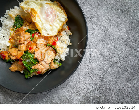 Rice topped with crispy pork belly with Thai basil and fried egg Rice topped with crispy pork belly with Thai basil and fried egg 116102314