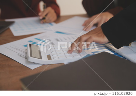 Group of confident business people point to graphs and charts to analyze market data, balance sheet, account, net profit to plan new sales strategies to increase production capacity. 116102920