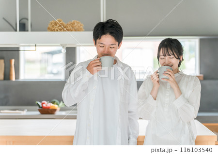 家のダイニングでコーヒー・お茶・ホットドリンクを飲む夫婦・カップル 116103540