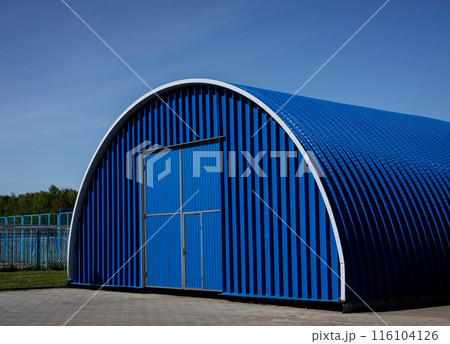 Blue Metal hangar oval against sky 116104126