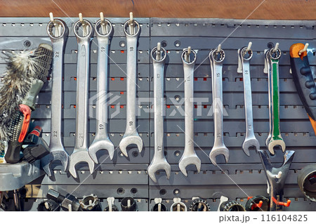 Wrenches hanging on the wall in a repair shop Wrenches hanging on the wall in a repair shop 116104825