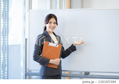 ホワイトボードの前でファイルを持ったビジネスウーマン 116105394