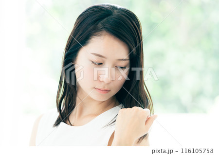 髪の傷みが気になる若い女性 116105758