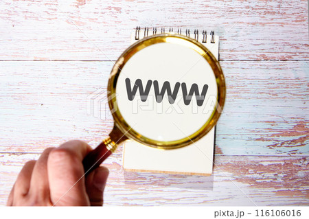 Internet business typography quotes concept. WWW World Wide Web found using a magnifying glass in a notebook 116106016