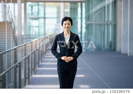 廊下に立つスーツを着たミドルビジネスウーマン 116106579