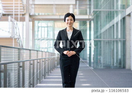 廊下に立つスーツを着たミドルビジネスウーマン 116106583