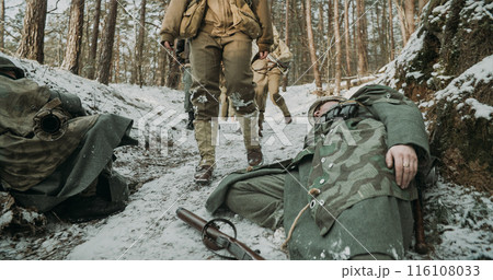American Infantry Soldier Pass By Corpses Of German Soldiers. Live And Dead At War. Group Of Usa Soldiers On March After Battle. Fallen Dead German Soldiers 116108033