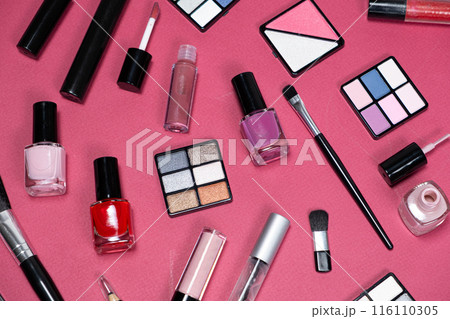 Various decorative cosmetics and brushes on a pink background, top view. 116110305
