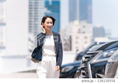 駐車場を歩く女性　ビジネス 116110558