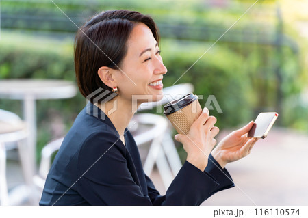 テラスでスマホを見る女性 116110574