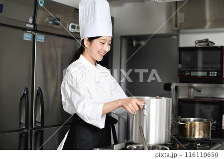 寸胴鍋で調理する若いアジア人の女性調理師 116110650