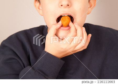 Caucasian man eating fried chicken balls, American fast food culture, cooked chicken pieces 116111663