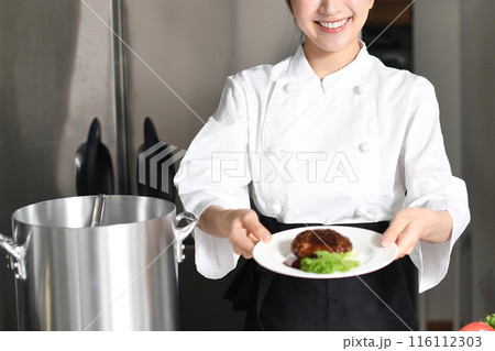 肉料理を提供する若いアジア人の女性調理師 116112303