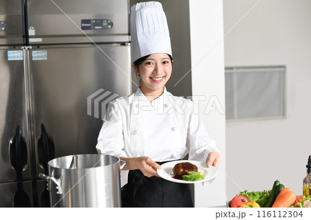 肉料理を提供する若いアジア人の女性調理師 116112304