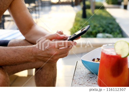 Casual Poolside Break with Smartphone and Mocktail 116112307