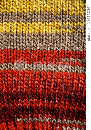 Handmade knitted fabric red yellow and beige wool background texture 116112364