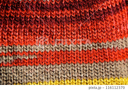 Handmade knitted fabric red yellow and beige wool background texture Handmade knitted fabric red yellow and beige wool background texture 116112370