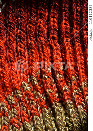 Handmade knitted fabric red and beige wool background texture 116112385