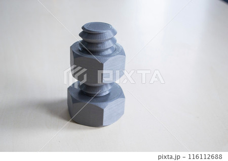 Object in form of washer and bolt printed on 3D printer. Three-dimensional model printed on 3D printer from molten plastic of red color. Concept 3D Printing. FDM 3D Printing technology 116112688