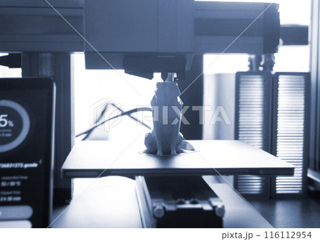 3D printer close-up. The process of working of 3D printer. 3D printer printing object from molten plastic. 3D printer creating model by flowing liquid plastic from an extruder. Printing technology 116112954