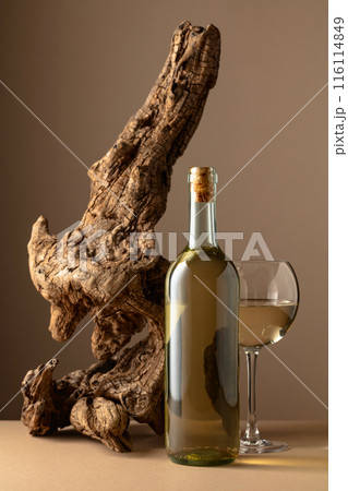 White wine and old snag on a beige background. 116114849