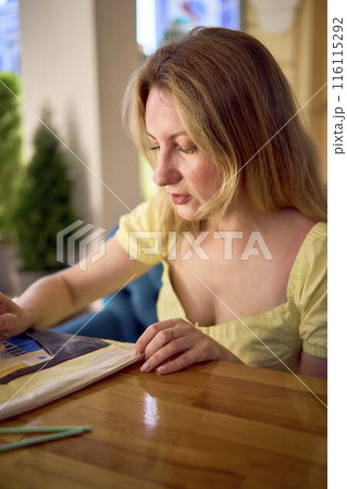a beautiful young artist in a yellow dress paints a customized shopping bag a beautiful young artist in a yellow dress paints a customized shopping bag 116115292