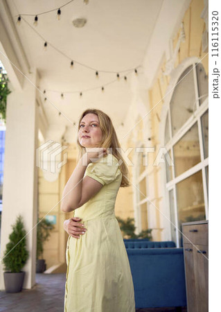 a beautiful young artist in a yellow vintage dress poses a beautiful young artist in a yellow vintage dress poses 116115320