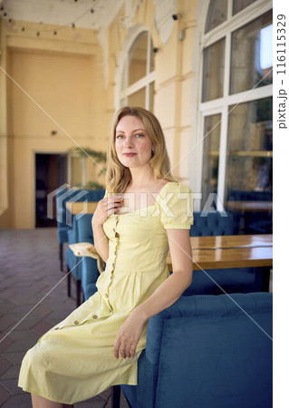 a beautiful young artist in a yellow vintage dress poses a beautiful young artist in a yellow vintage dress poses 116115329