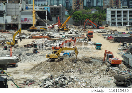 Many excavators working on the ground of the construction site while removing the salvage after the destruction of the building 116115480