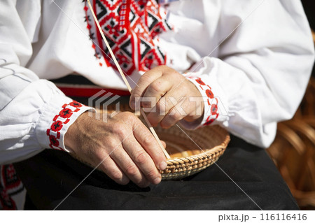 The hands of a craftsman make products from birch bark. The hands of a craftsman make products from birch bark. 116116416