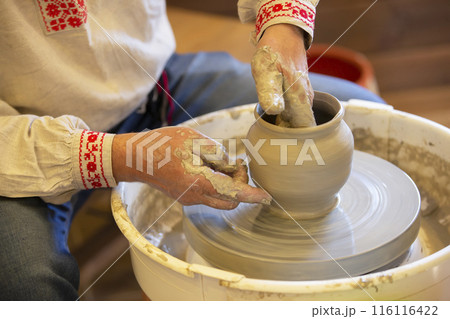 The hands of the master make a pot of clay. 116116422