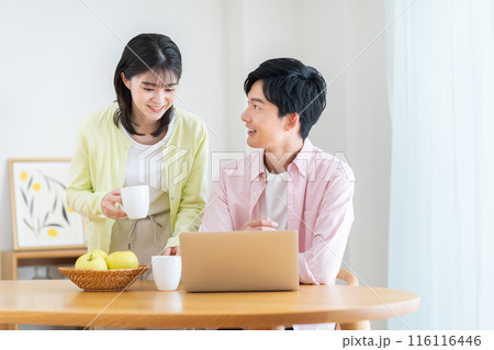 ダイニングでパソコンを見る若い夫婦 ダイニングでパソコンを見る若い夫婦 116116446