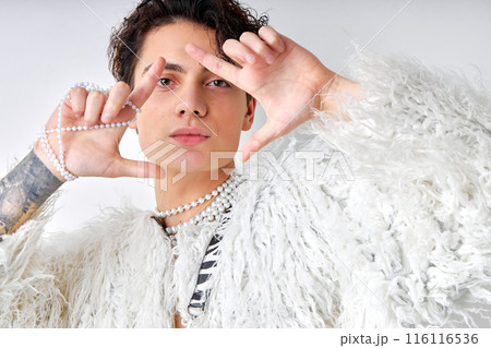 young brunette hispanic gay man with natural make up looking at camera isolated 116116536