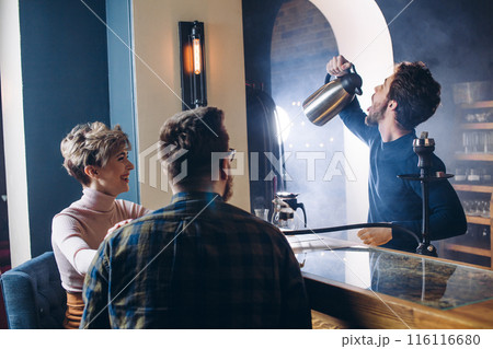 funny barmen entertaining his guests 116116680