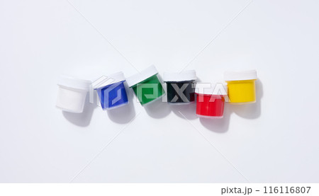 Plastic jars with multi-colored gouache on a white background 116116807