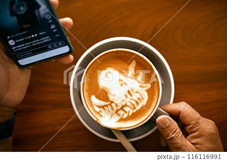 a cup of hot latte art coffee on wooden table 116116991