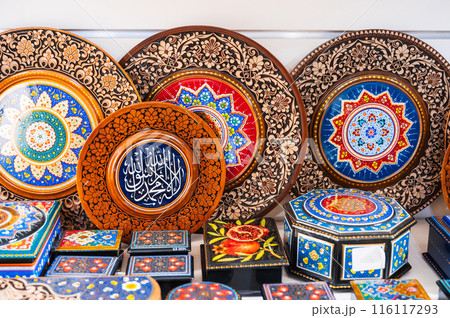 handmade Uzbek wooden gift plates and paintings with wood carvings hand-painted traditional patterns in the souvenir shop in Uzbekistan in Tashkent handmade Uzbek wooden gift plates and paintings with wood carvings hand-painted traditional patterns in the souvenir shop in Uzbekistan in Tashkent 116117293