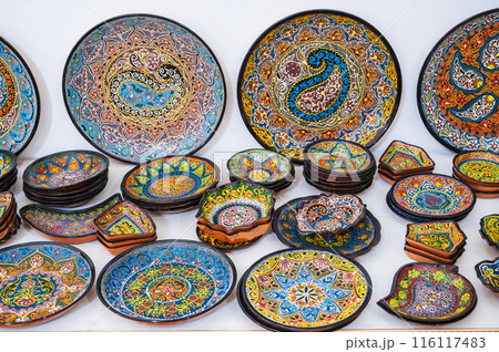 colorful oriental Uzbek ceramic plates hand-painted at souvenir tableware market 116117483