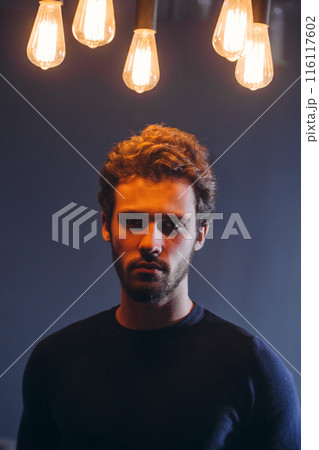 attractive Caucasian guy with serious look posing to the camera 116117602