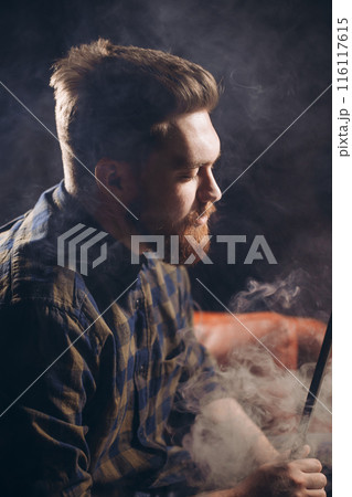 drunken young man smoking at the bar 116117615