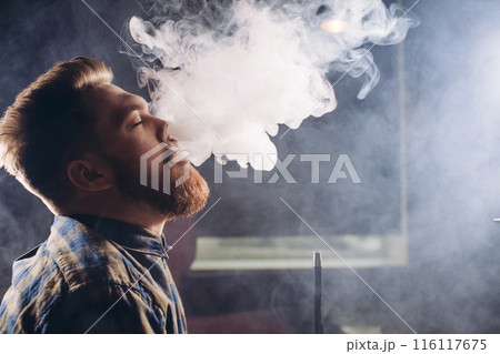 handsome guy is relish smoking at bar 116117675