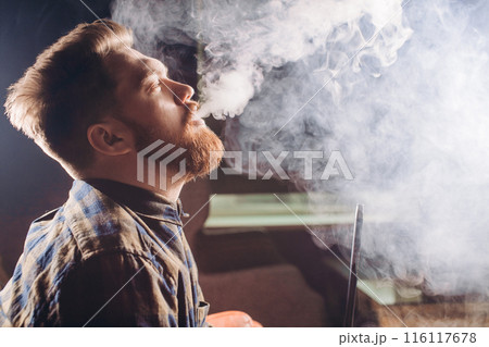 magicical smoking. young man relaxing with hookah magicical smoking. young man relaxing with hookah 116117678
