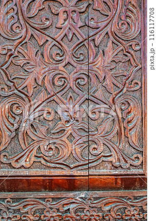 arabic Uzbek Islamic kandakori patterns arabesque ornament on an wooden carved door in Uzbekistan close-up 116117708