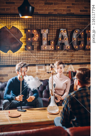pleasant young people in fashion clothes chatting at the cafe 116117794
