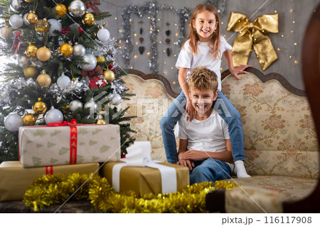 Little girl and boy on the sofa before Christmas Little girl and boy on the sofa before Christmas 116117908