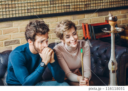 cheerful couple in fashion clothes spending time in the cafe 116118031