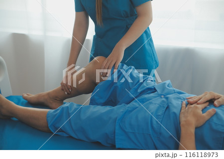 Physical therapists work with patients in close-up clinics. The concept of rehabilitation of physical health, the doctor gives advice to the patient. Ankle problems and muscle injuries Physical therapists work with patients in close-up clinics. The concept of rehabilitation of physical health, the doctor gives advice to the patient. Ankle problems and muscle injuries 116118973