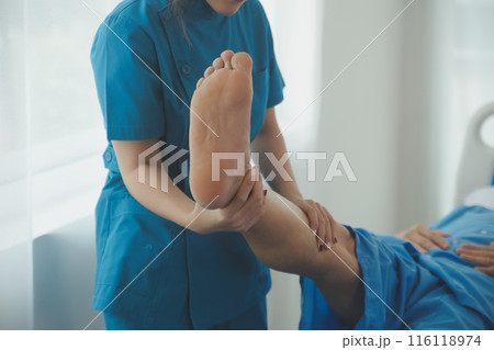 Physical therapists work with patients in close-up clinics. The concept of rehabilitation of physical health, the doctor gives advice to the patient. Ankle problems and muscle injuries Physical therapists work with patients in close-up clinics. The concept of rehabilitation of physical health, the doctor gives advice to the patient. Ankle problems and muscle injuries 116118974