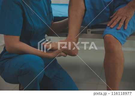 Physical therapists work with patients in close-up clinics. The concept of rehabilitation of physical health, the doctor gives advice to the patient. Ankle problems and muscle injuries Physical therapists work with patients in close-up clinics. The concept of rehabilitation of physical health, the doctor gives advice to the patient. Ankle problems and muscle injuries 116118977
