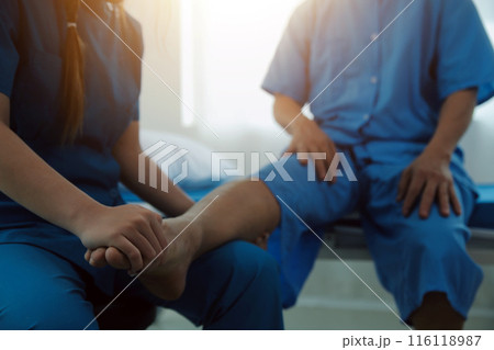 Physical therapists work with patients in close-up clinics. The concept of rehabilitation of physical health, the doctor gives advice to the patient. Ankle problems and muscle injuries Physical therapists work with patients in close-up clinics. The concept of rehabilitation of physical health, the doctor gives advice to the patient. Ankle problems and muscle injuries 116118987